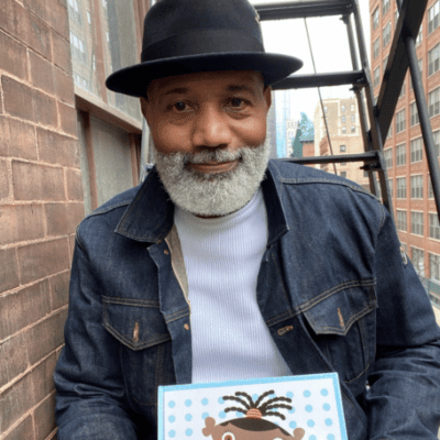 Photograph of Michael Tyler holding a copy of his children's book.